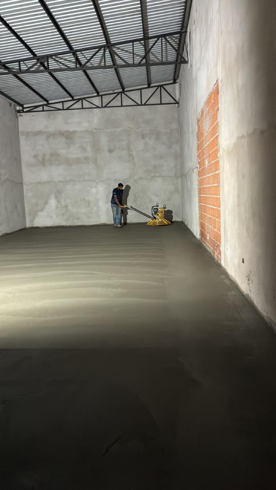 operador da Brito e Pauluci acabando piso de concreto fresco com alisadora
